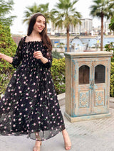 model wearing black floral smocked dress