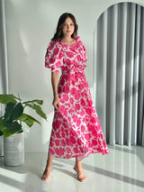 model wearing long pink floral dress